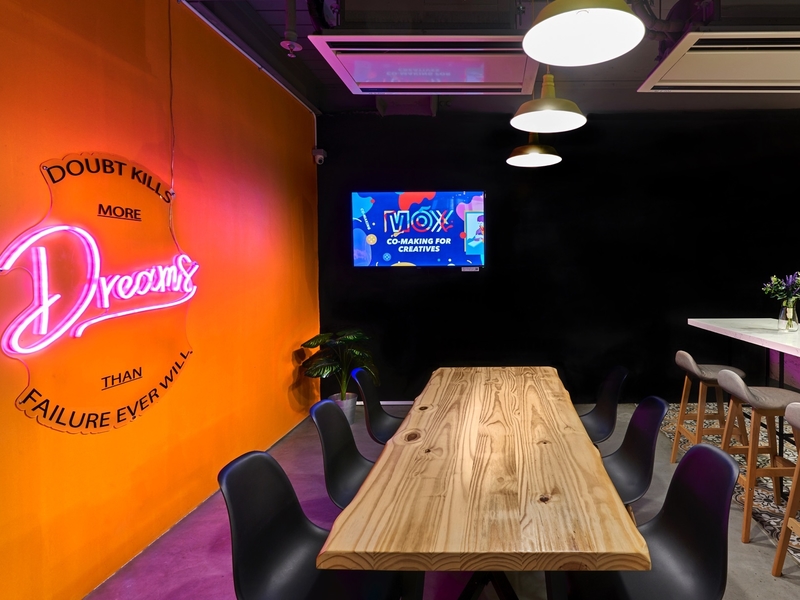 singapore coworking space with black-orange meeting room and wooden table