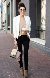 lady holding a cup of coffee with light top and black pants