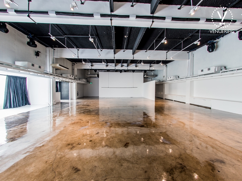 Wide space with hardwood floor and white walls and ceiling lights