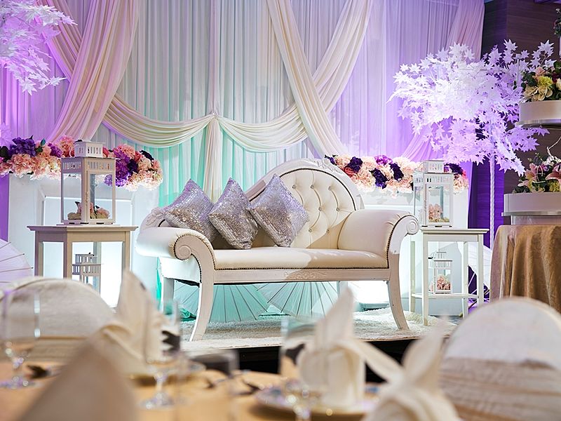 White sofa and silver cushions against white curtain background