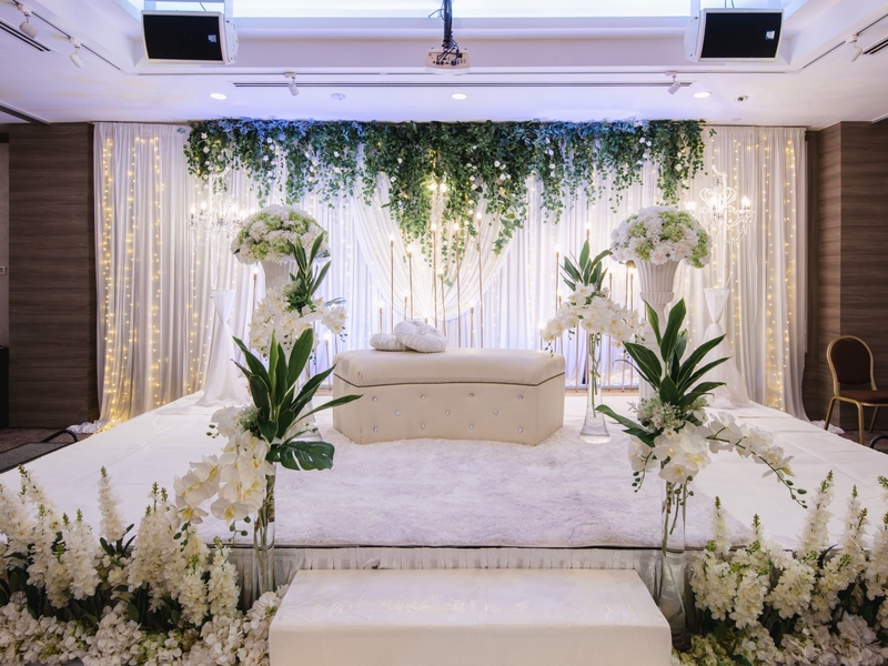 Function venue with white sofa and white floral decoration and fairy lights