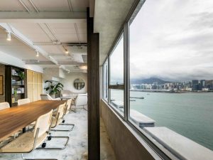 Room with long table, couches and a partial view of Hong Kong Harbour
