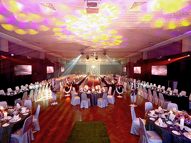 disco lights in a function hall with tables and chairs