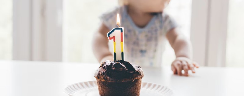 A brown cupcake with a "1" candle on it