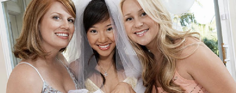 Two women with a smiling bride in the middle